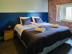 a bedroom with a bed with two pillows on it at Ruim sfeervol appartement naast wijndomein in Vijlen, Zuid-Limburg in Vijlen
