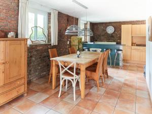 a kitchen and dining room with a wooden table and chairs at Ruim sfeervol appartement naast wijndomein in Vijlen, Zuid-Limburg in Vijlen