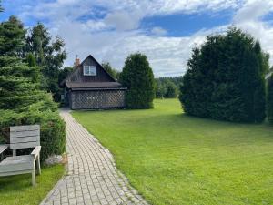 a bench in front of a house with a grass yard at Avoti in Jūrkalne