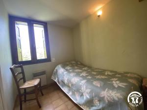 a bedroom with a bed and a chair and a window at Ribelles in Eus