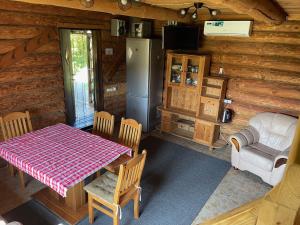 a dining room with a table and a refrigerator at Avoti in Jūrkalne