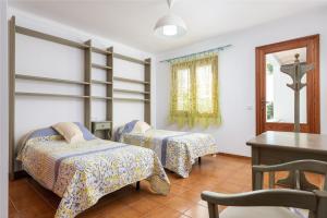 a bedroom with two beds and a table and a desk at Estrel in Can Picafort +45 photos