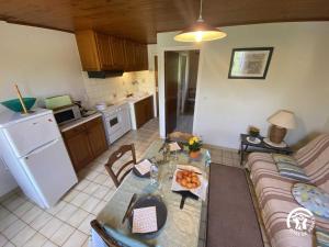 a kitchen and a living room with a couch and a table at Mas garrigole in Eus
