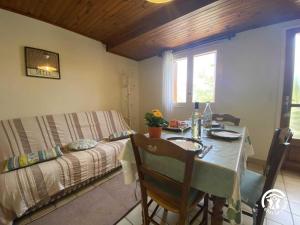 a dining room with a table and a bed at Mas garrigole in Eus