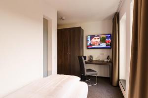a bedroom with a bed and a desk with a tv at Hotel DuDa Langenbruck 3-Sterne-Superior-Hotel an der A9 zwischen Ingolstadt und München in Langenbruck
