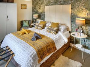 a bedroom with a large bed with yellow pillows at Lock Heather Cottage in Reeth