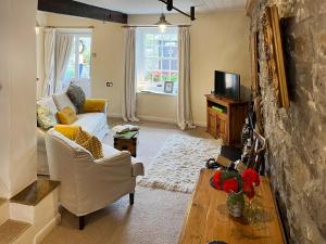 a living room with a couch and a tv at Lock Heather Cottage in Reeth