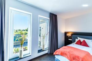 a bedroom with a bed and a large window at Hotel DuDa Langenbruck 3-Sterne-Superior-Hotel an der A9 zwischen Ingolstadt und München in Langenbruck