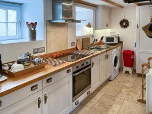 a kitchen with a sink and a stove top oven at Lock Heather Cottage in Reeth +7 photos