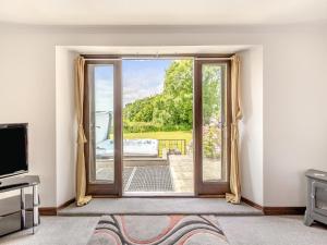 a living room with a door open to a patio at Holgates in Upottery