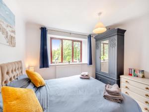 a bedroom with a blue bed and a window at Holgates in Upottery +18 photos