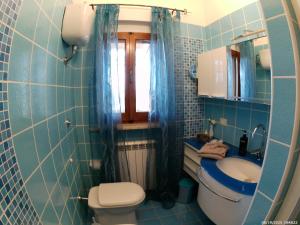 a blue tiled bathroom with a toilet and a sink at Locazione Turistica Spaccarotella Vista su Gualdo Cattaneo in Gualdo Cattaneo