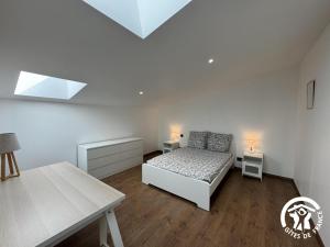 a white bedroom with a bed and two tables at Les mains du soleil in Millas +5 photos