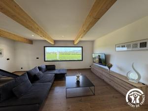 a living room with a couch and a table at Les mains du soleil in Millas