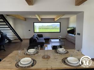 a living room with a table and a couch at Les mains du soleil in Millas