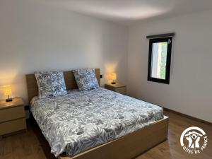 a bedroom with a bed and two night stands at Les mains du soleil in Millas