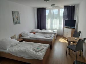 a room with three beds and a tv and a desk at HOMER Bydgoszcz Ośrodek Rehabilitacji i Szkolenia PZN in Bydgoszcz +72 photos
