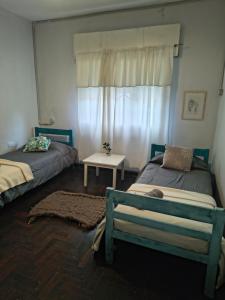 a bedroom with two beds and a window at Casona Antigua con Jacuzzi a metros de la Basílica de Luján in Luján