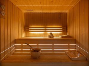 a sauna with a bench and a bucket in it at Mercure Le Mans Batignolles - Hotel & Spa in Le Mans