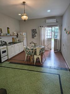 a kitchen with a table and chairs and a kitchen with a refrigerator at Casona Antigua con Jacuzzi a metros de la Basílica de Luján in Luján
