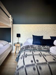 a bedroom with a large bed with blue pillows at Le Clos des Poncétys - gîte de charme avec piscine dans les vignes de Bourgogne in Davayé +45 photos