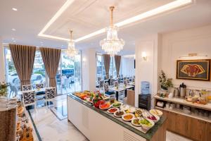 a buffet in a restaurant with food on a counter at Hotel Oasis in Sarandë +133 photos