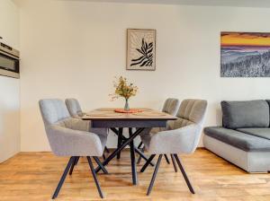 a dining room with a table and chairs and a couch at Apartment Kapina in Pamporovo
