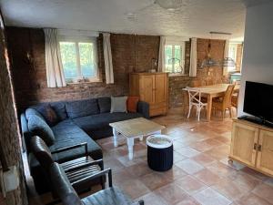 a living room with a couch and a table at Ruim sfeervol appartement naast wijndomein in Vijlen, Zuid-Limburg in Vijlen