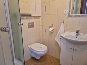 a small bathroom with a toilet and a sink at Malinowe Lato in Grzybowo +62 photos