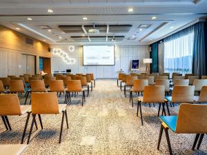 a conference room with chairs and a projection screen at Novotel Reims Tinqueux in Reims