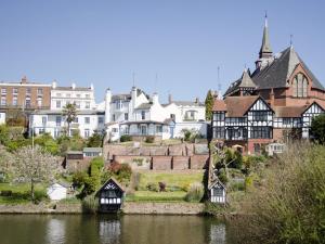 a group of houses on a hill next to a body of water at Weetwood Lodge in Kelsall