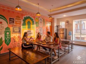 a group of people sitting at a table in a restaurant at Zostel Jaipur in Jaipur
