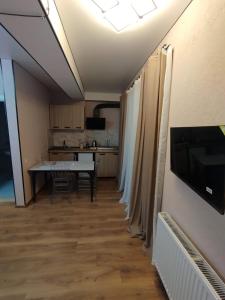 a living room with a table and a kitchen at Hotel G&G in Tsaghveri