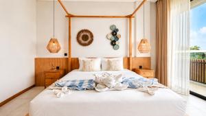 a bedroom with a bed and a window and pendant lights at 4Bedroom Umah Jeng Alessia Villa - Pererenan by SooBali in Munggu