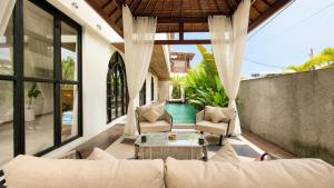 an outdoor patio with a couch and a table at 4Bedroom Umah Jeng Alessia Villa - Pererenan by SooBali in Munggu