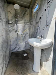 a bathroom with a white sink and a marble wall at Kambar-ata yurt camp in Song-Kul +10 photos
