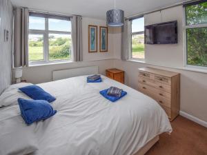 a bedroom with a large white bed with blue pillows at Station House in St Bees