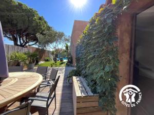 a patio with a table and chairs and a plant at L'hacienda in Pia