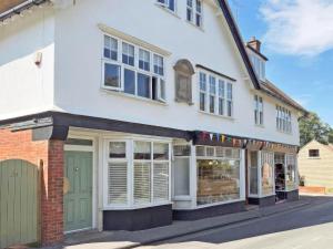 a white building with a green door on a street at Beaconsfield House in Mundesley