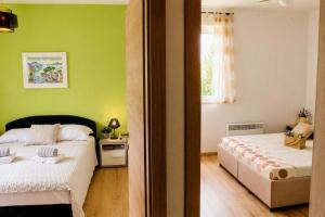 a bedroom with two beds and green walls at Casa Ondina - Private House with Jacuzzi & Big Garden in Central Istria in Šumber