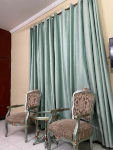 two chairs and a table in front of a curtain at 6Bedroom Villa DHA Lahore in Lahore
