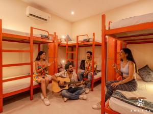 a group of people sitting in a room with bunk beds at Zostel Jaipur in Jaipur
