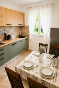a kitchen with a table with plates on it at Casa Ondina - Private House with Jacuzzi & Big Garden in Central Istria in Šumber