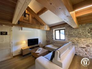 a living room with a couch and a tv at Les pérics in Puyvalador