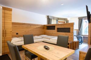 a dining room with a table and a couch at Hotel Orchidea in Passo del Tonale