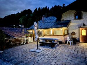 a patio with a ping pong table and an umbrella at Dolomiti Cadore Home in San Pietro di Cadore
