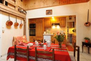 a kitchen with a table with a red table cloth at Le moulin in Sahorre