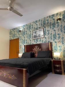 a bedroom with a bed with blue wallpaper at 6Bedroom Villa DHA Lahore in Lahore
