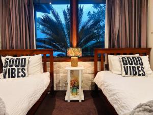 two beds in a room with a window at Moon light Retreat in Whittlesea +21 photos