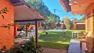 an outdoor patio with a table and chairs in a yard at Bella vida Geriba suites in Búzios